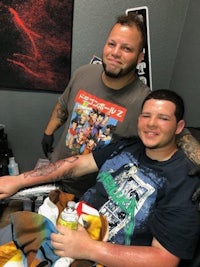 a man with a tattoo on his arm and a man with a tattoo on his arm